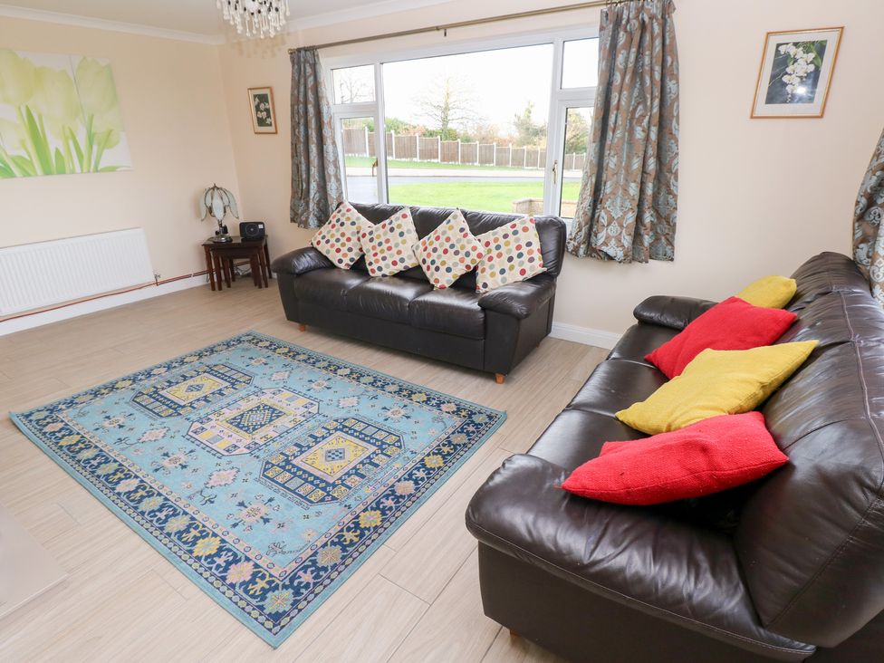A living room with sofas and a rug at Cherry Trees in Haverfordwest