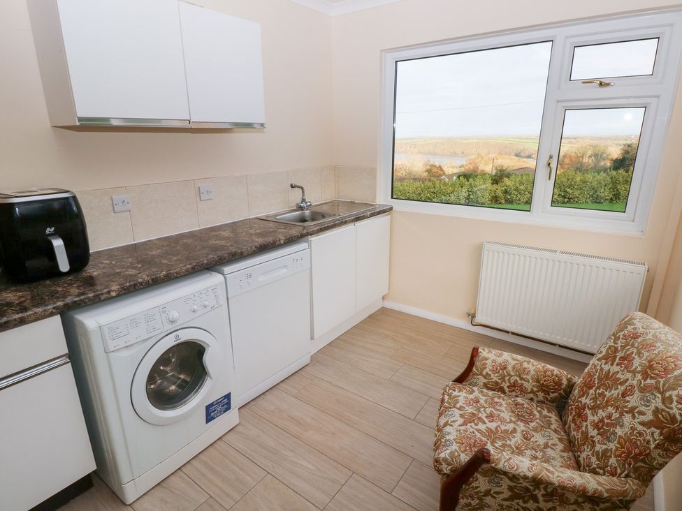 A kitchen with a washing machine and a view at Cherry Trees in Haverfordwest