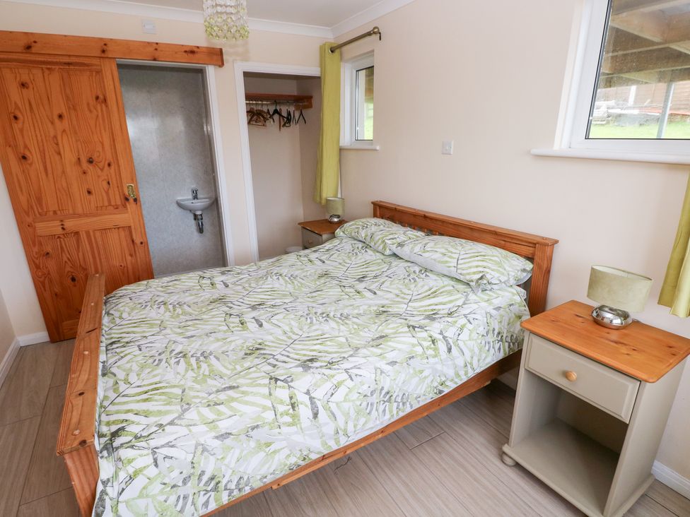 A bedroom with a bed and a bedside table at Cherry Trees in Haverfordwest