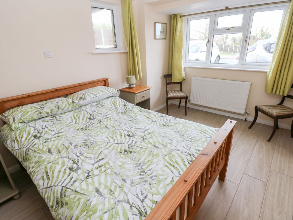 A bedroom with a bed, bedside table, and chairs at Cherry Trees in Haverfordwest