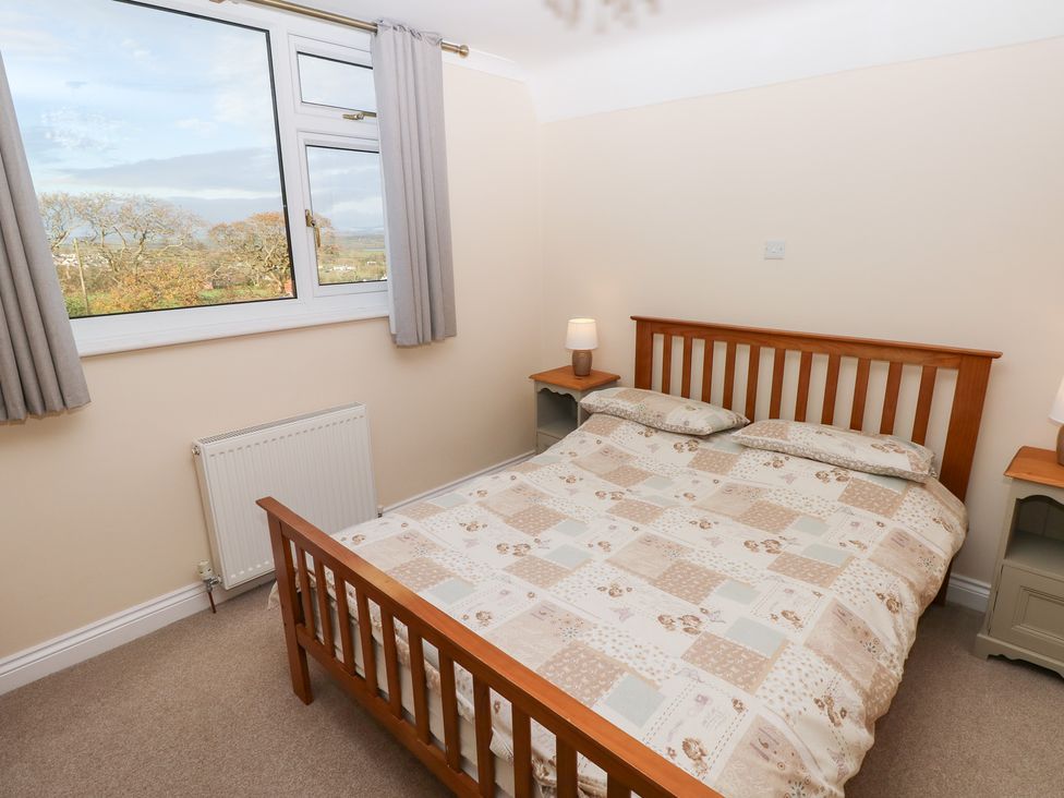 A bedroom with a bed and window at Cherry Trees in Haverfordwest
