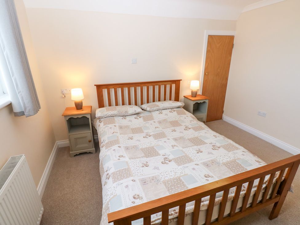 A bedroom with a bed and nightstands at Cherry Trees in Haverfordwest