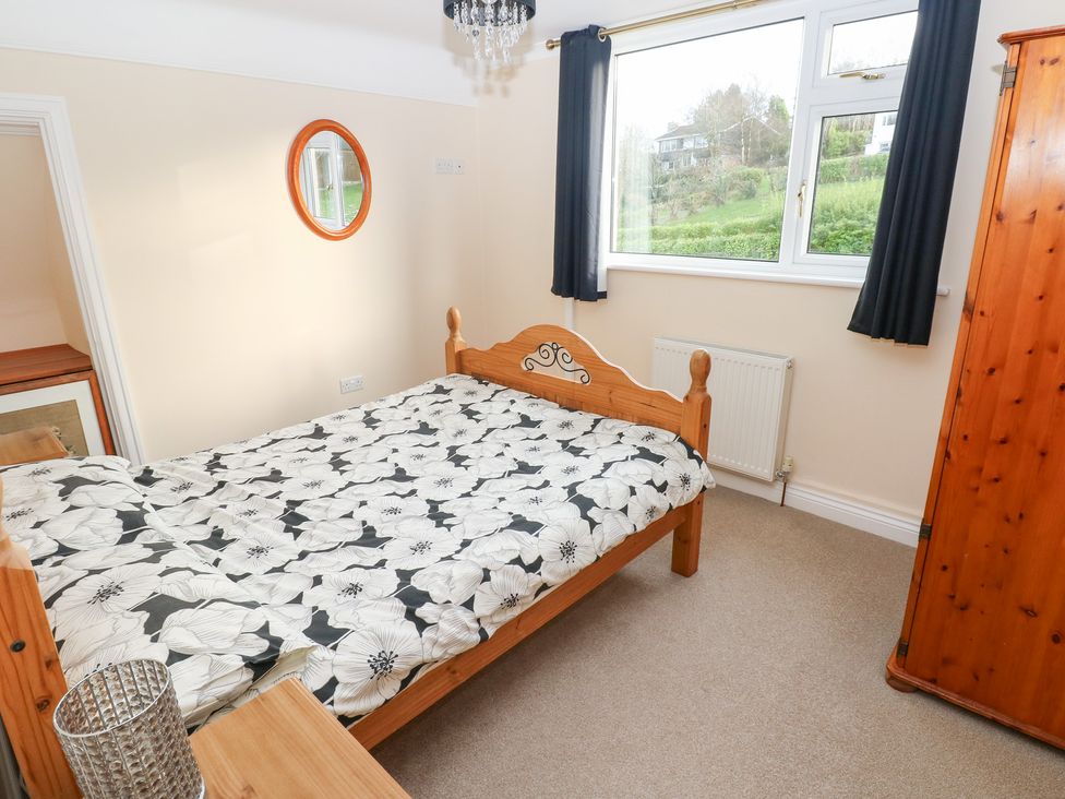 A bedroom with a bed and wardrobe at Cherry Trees in Haverfordwest