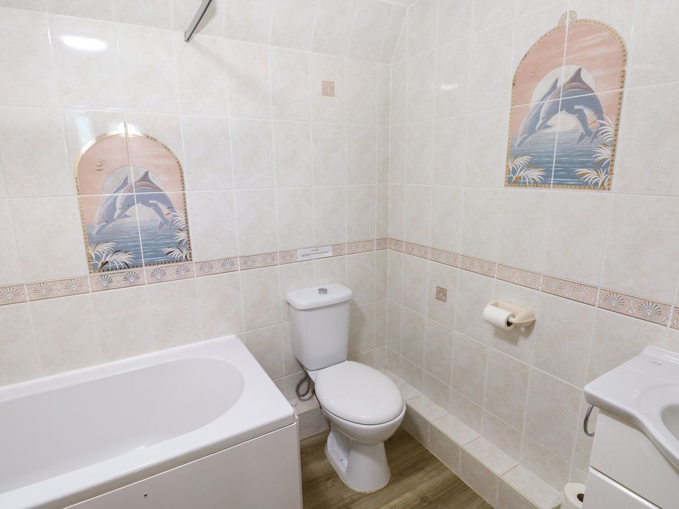 A bathroom with a bathtub and toilet at Cherry Trees in Haverfordwest