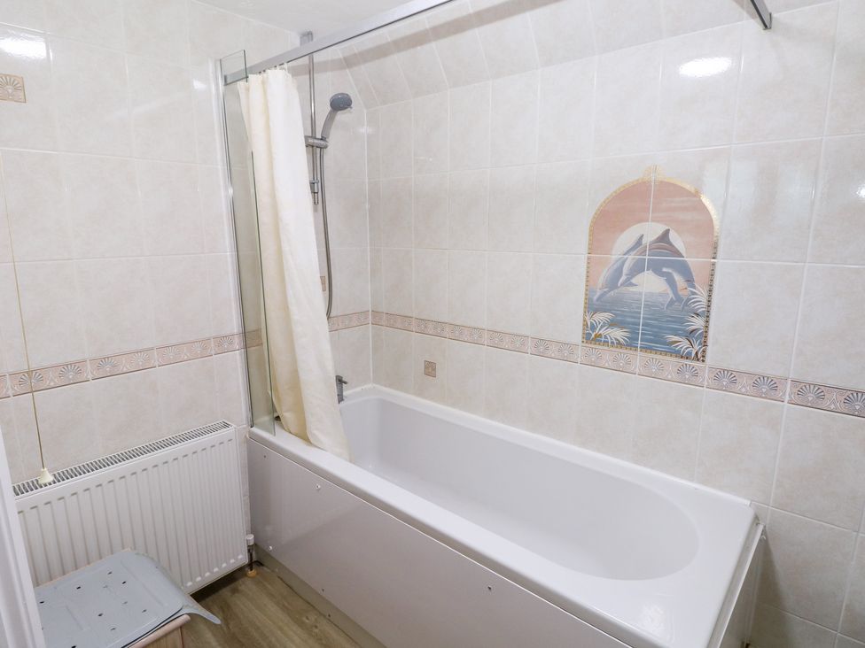 A bathroom with a bathtub and shower at Cherry Trees in Haverfordwest
