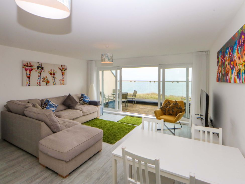 A living room with a sofa and table at Welymora Pwllheli