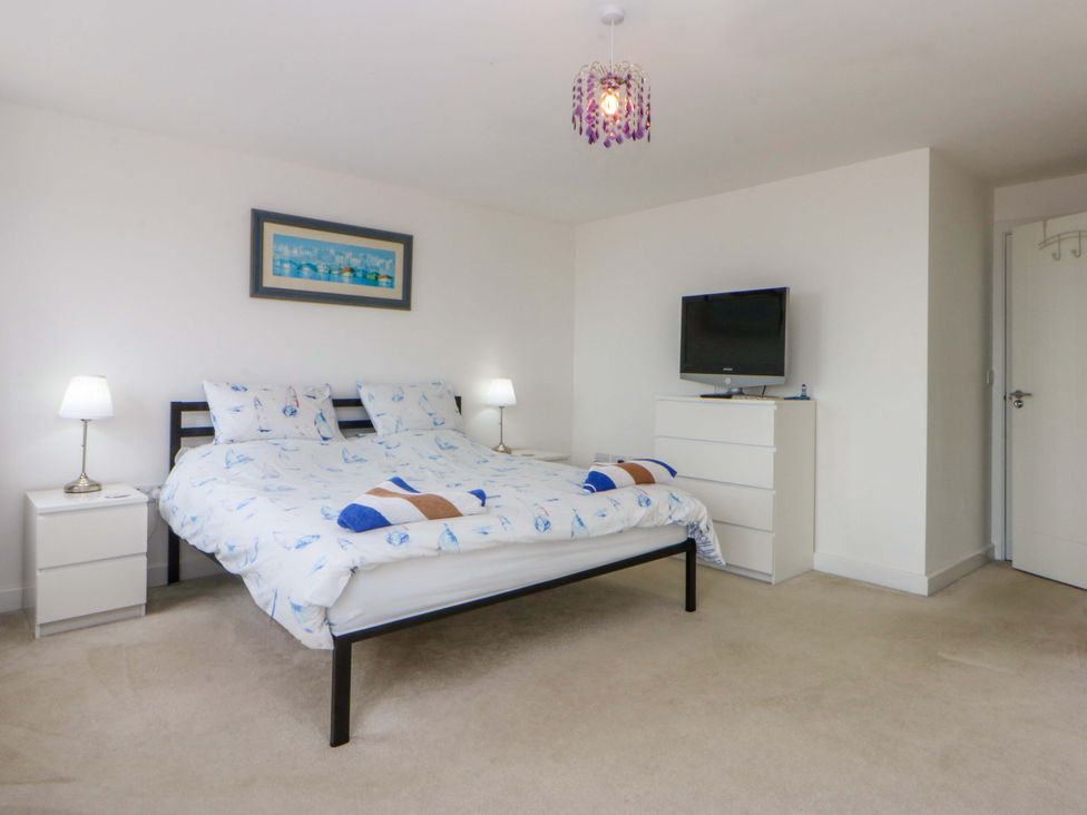 A bedroom with a bed and television at Welymora in Pwllheli