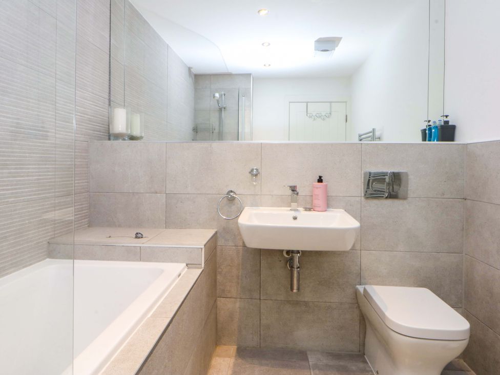 A bathroom with a bathtub, sink, and toilet at Welymora Pwllheli
