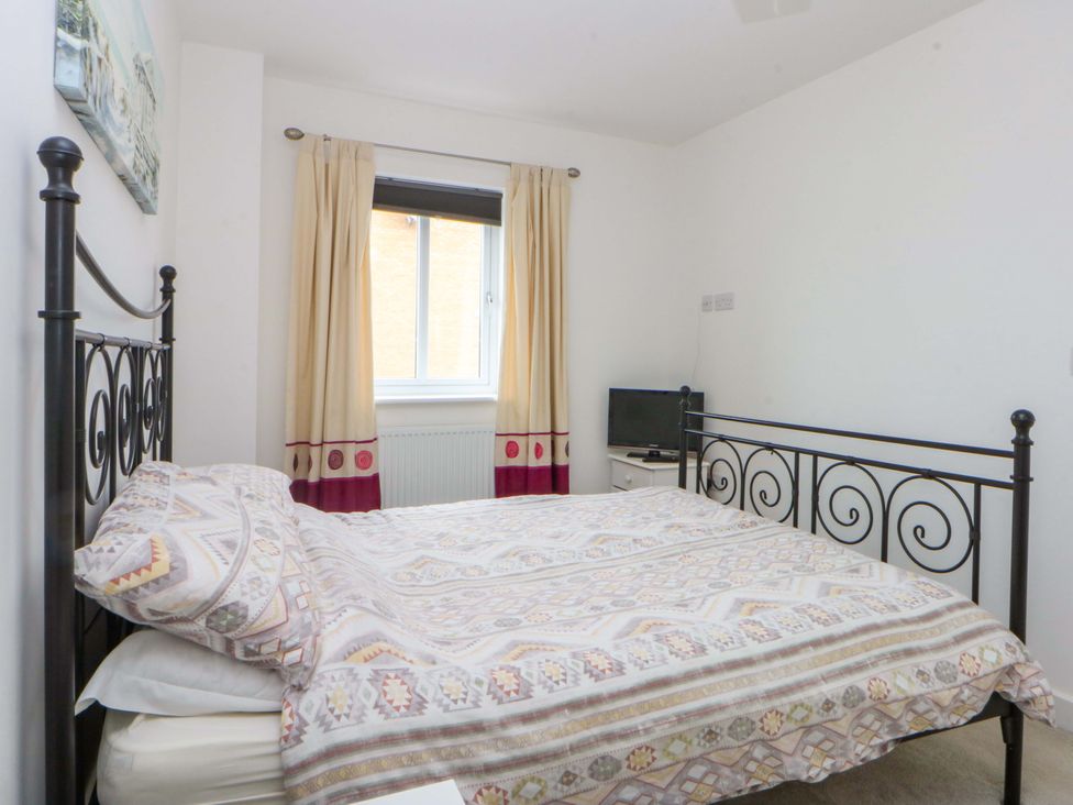 A bedroom with a bed and a tv at Welymora in Pwllheli