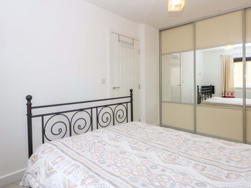 A bedroom with a bed and mirror at Welymora in Pwllheli