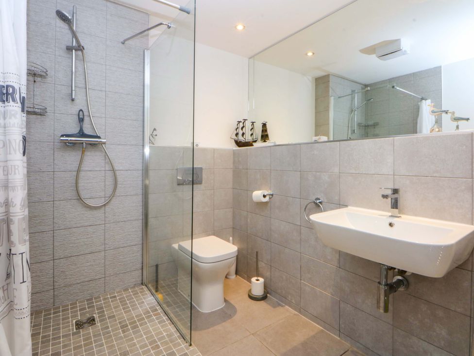 A bathroom with a shower, toilet, and sink at Welymora in Pwllheli