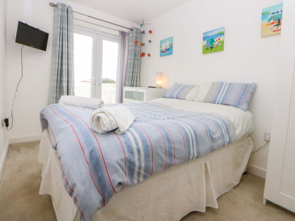 A bedroom with a bed and television at Welymora in Pwllheli