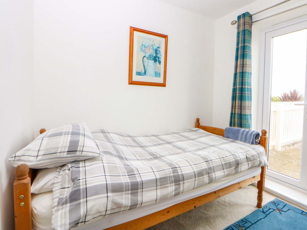 A bedroom with a single bed and a window at Welymora in Pwllheli