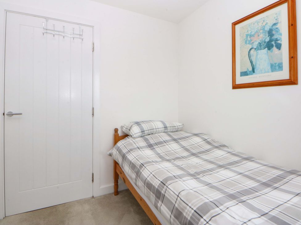 A bedroom with a bed and a door at Welymora, Pwllheli