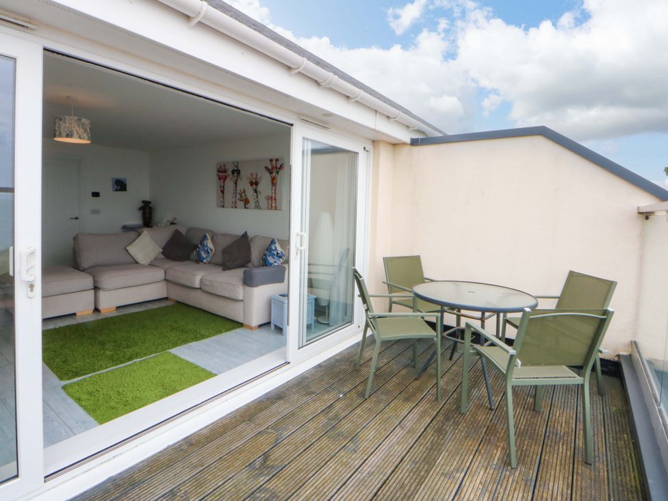 A balcony with a table and chairs at Welymora in Pwllheli