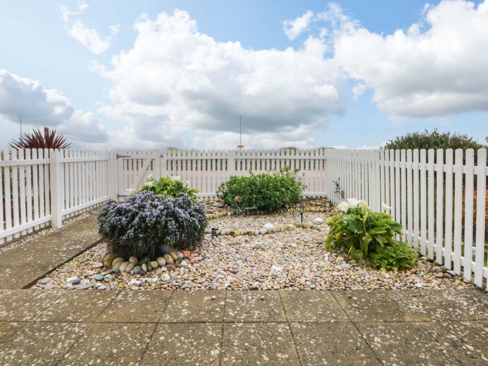 A garden area with stones and flowers at Welymora Pwllheli