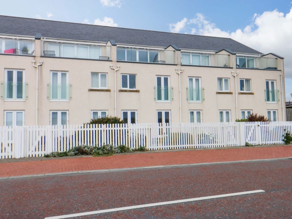 A building with multiple windows and a white fence at Welymora in Pwllheli