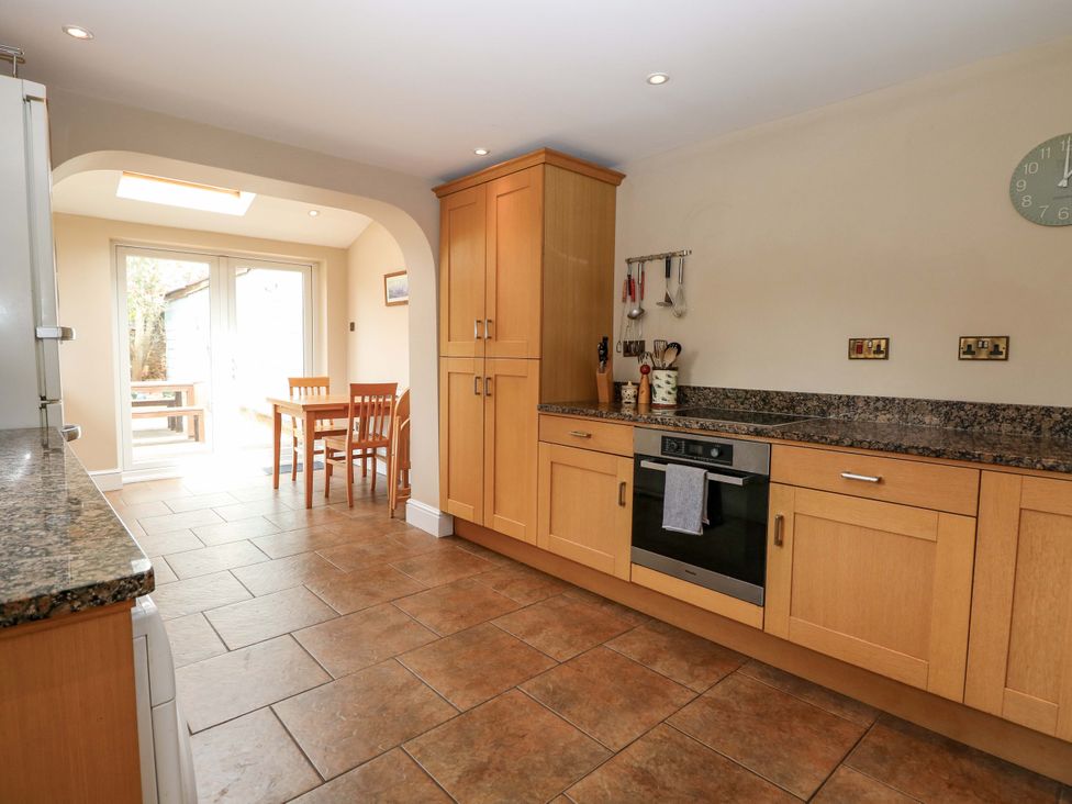 A kitchen with an oven and a dining table at Tilly's Retreat in Hunstanton