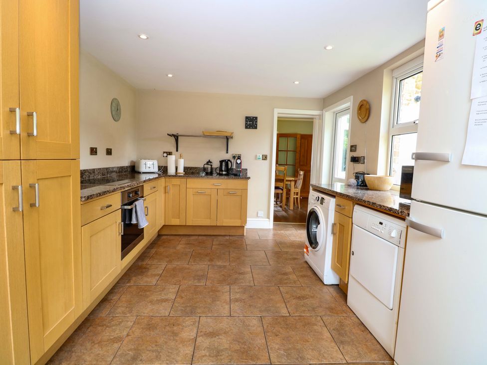 A kitchen with oak cabinets and appliances at Tilly's Retreat in Hunstanton