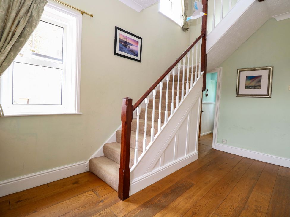 A hallway with stairs and window at Tilly's Retreat in Hunstanton