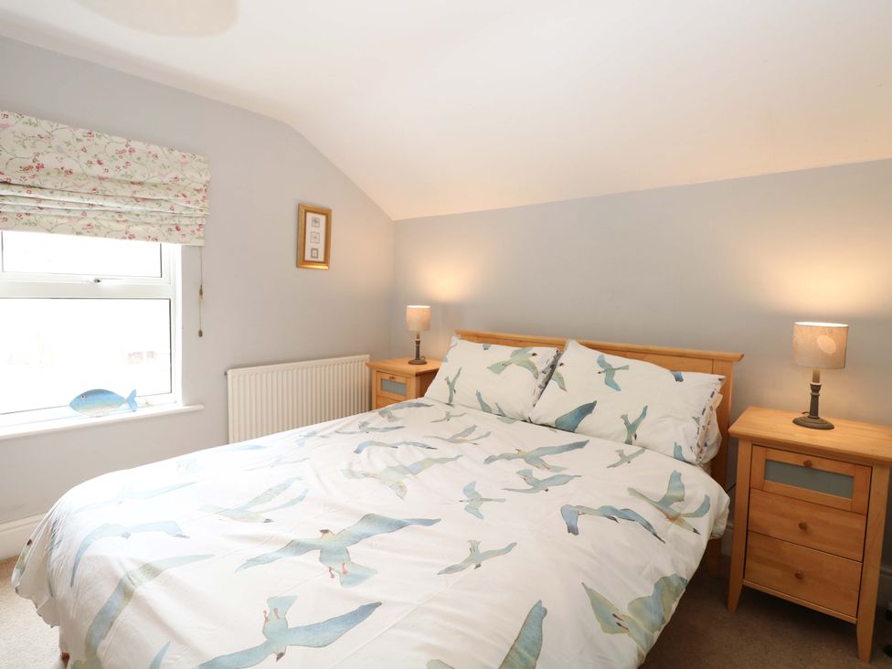A bedroom with a bed and bedside tables at Tilly's Retreat in Hunstanton