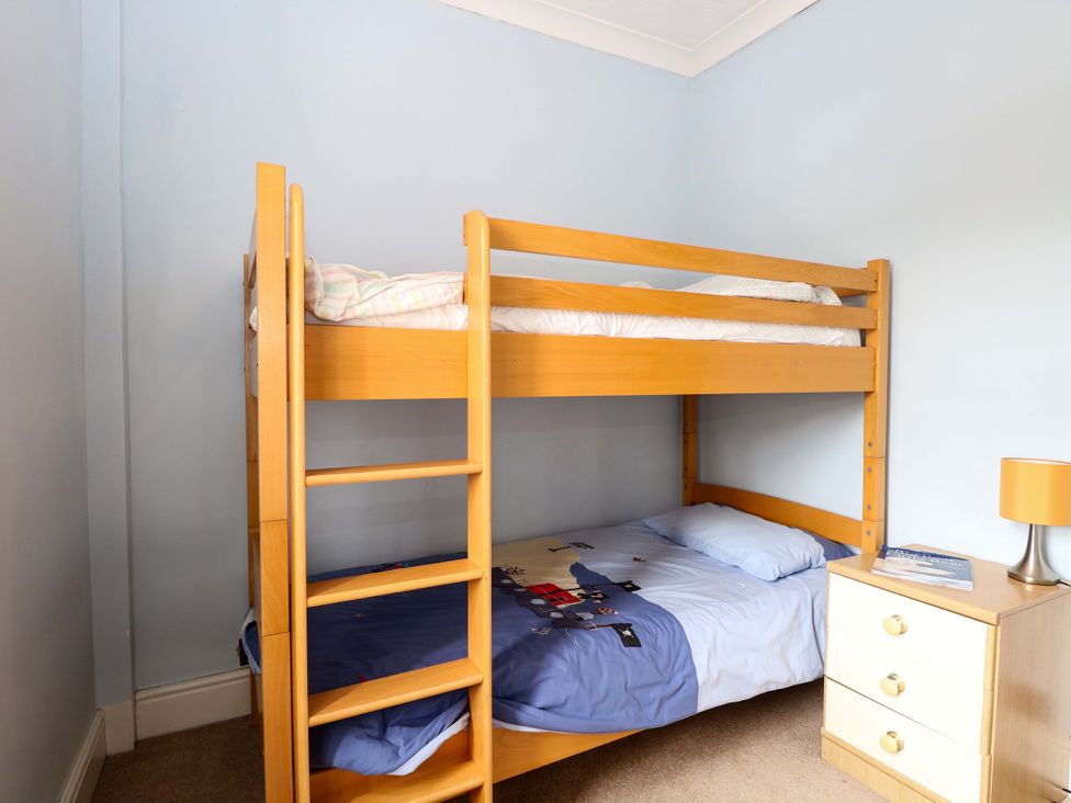 A bunk bed and bedside table in a bedroom at Tilly's Retreat in Hunstanton