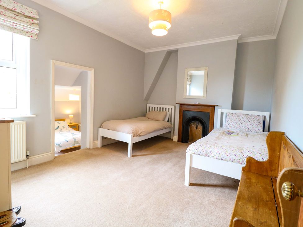 A bedroom with two beds and a fireplace at Tilly's Retreat in Hunstanton
