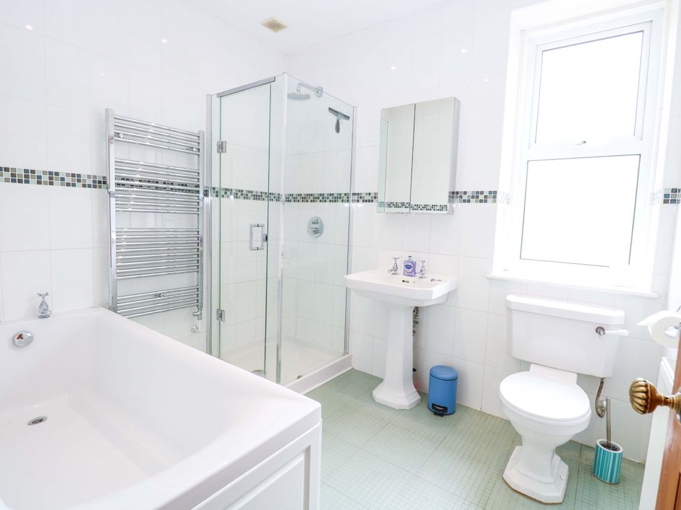 A bathroom with a shower, bathtub, and sink at Tilly's Retreat in Hunstanton