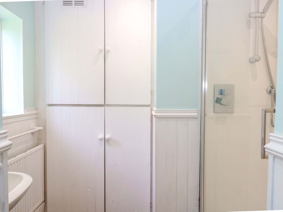 A bathroom featuring a shower and cupboard at Tilly's Retreat in Hunstanton