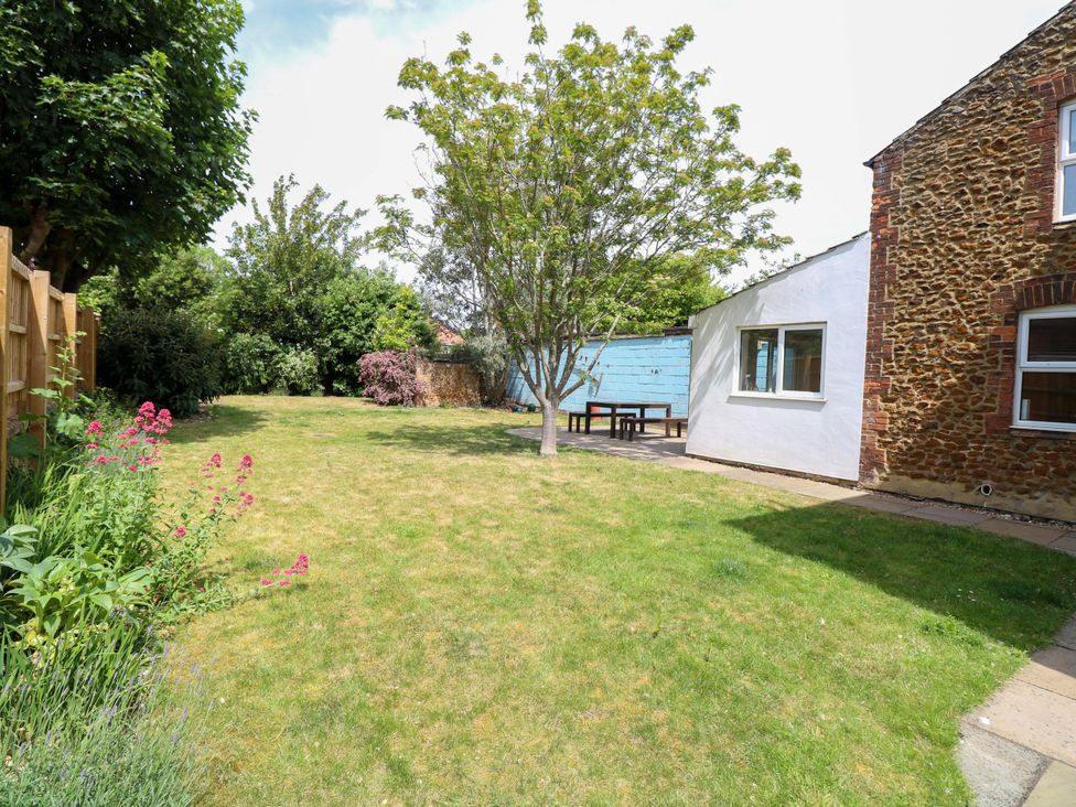 A garden with a tree and table at Tilly's Retreat in Hunstanton