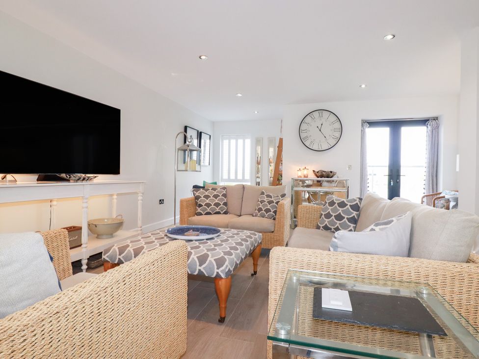 A living room with a television, sofa, and coffee table at Seaspell Beach House, Constantine Bay