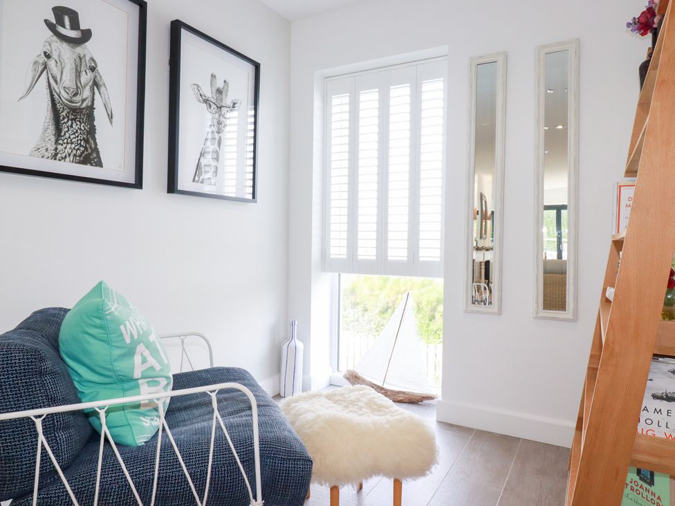 A living room with a sofa and artwork at Seaspell Beach House in Constantine Bay