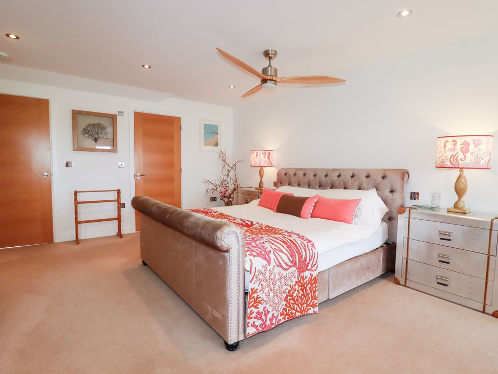 A bedroom with a bed and bedside lamps at Seaspell Beach House in Constantine Bay