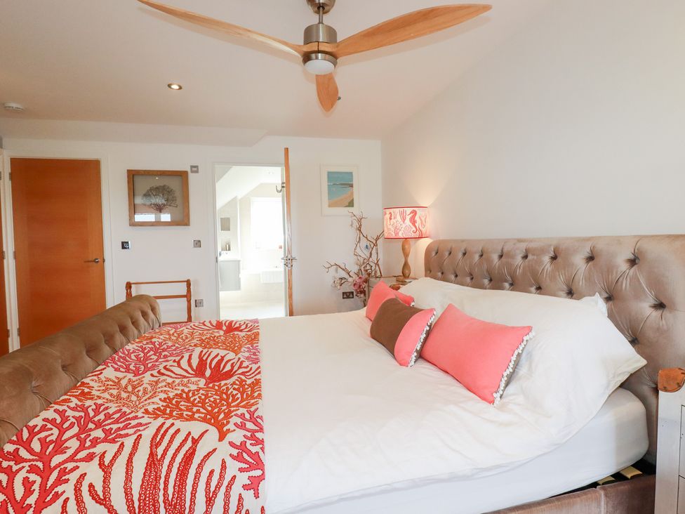 A bedroom with a bed and artwork at Seaspell Beach House in Constantine Bay