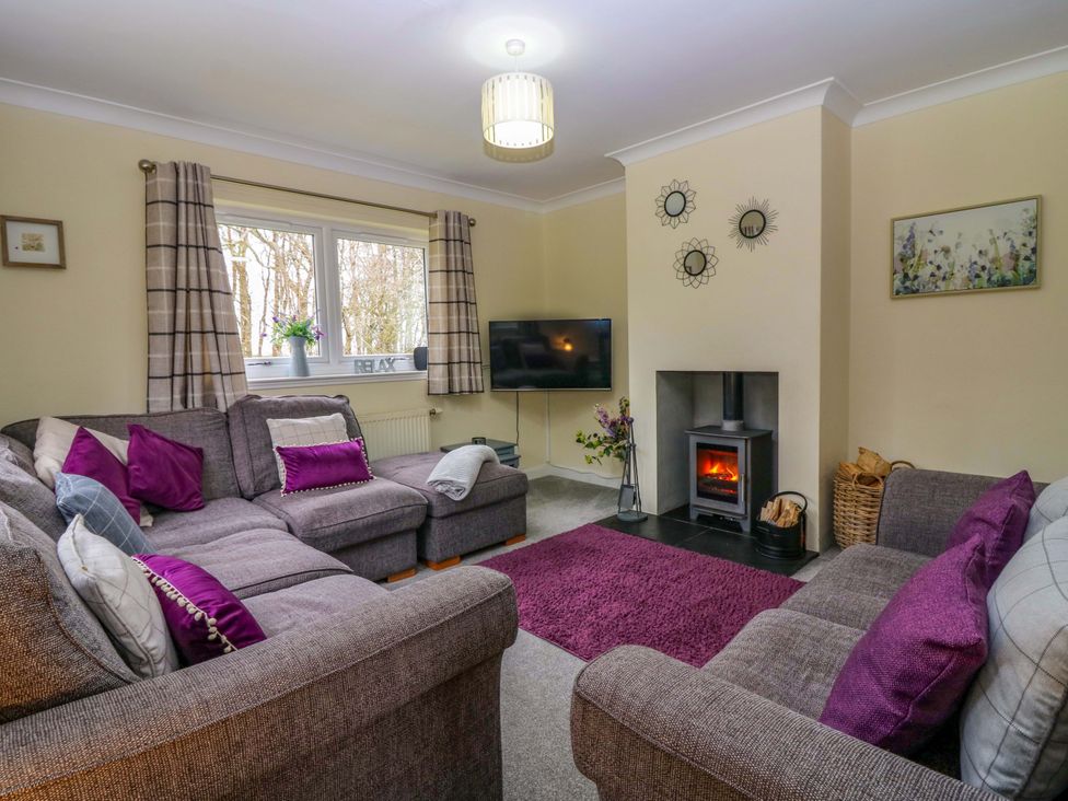 A living room with a sofa and television at Falla Farmhouse in Jedburgh