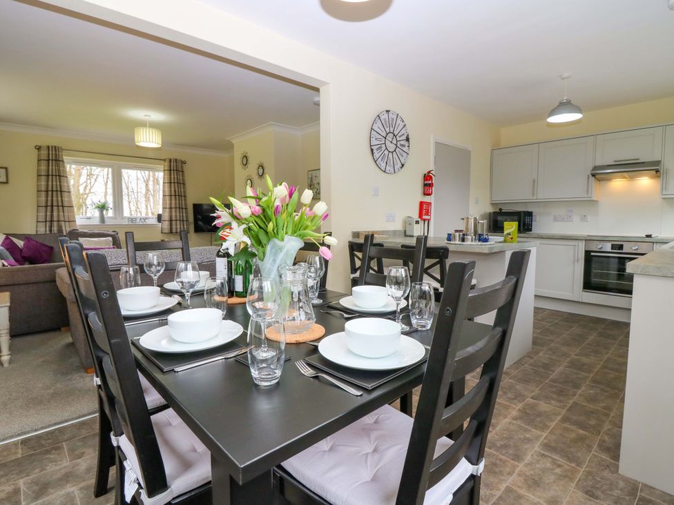 A kitchen with a dining table set at Falla Farmhouse in Jedburgh