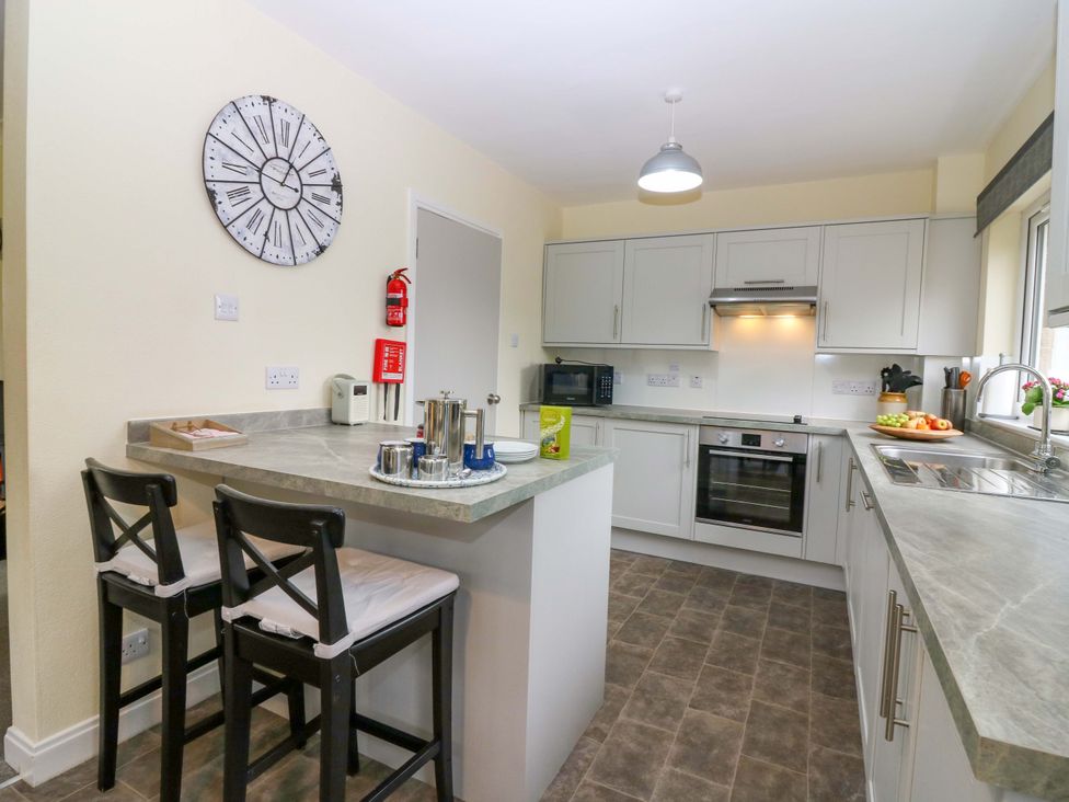 A kitchen with a fruit bowl and bar stools at Falla Farmhouse in Jedburgh