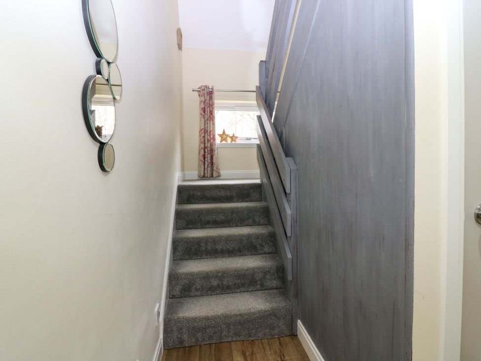 A staircase with mirrors and curtains at Falla Farmhouse in Jedburgh