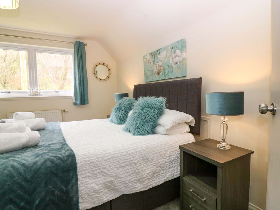 A bedroom with a bed and bedside table at Falla Farmhouse in Jedburgh