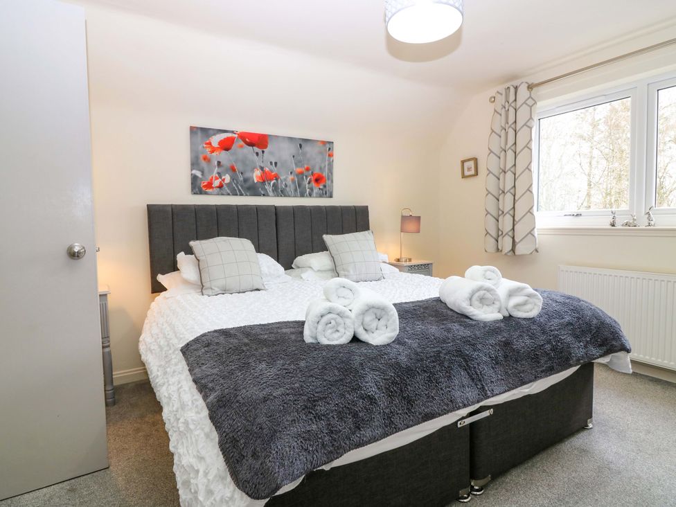 A bedroom with a bed and bedside table at Falla Farmhouse in Jedburgh