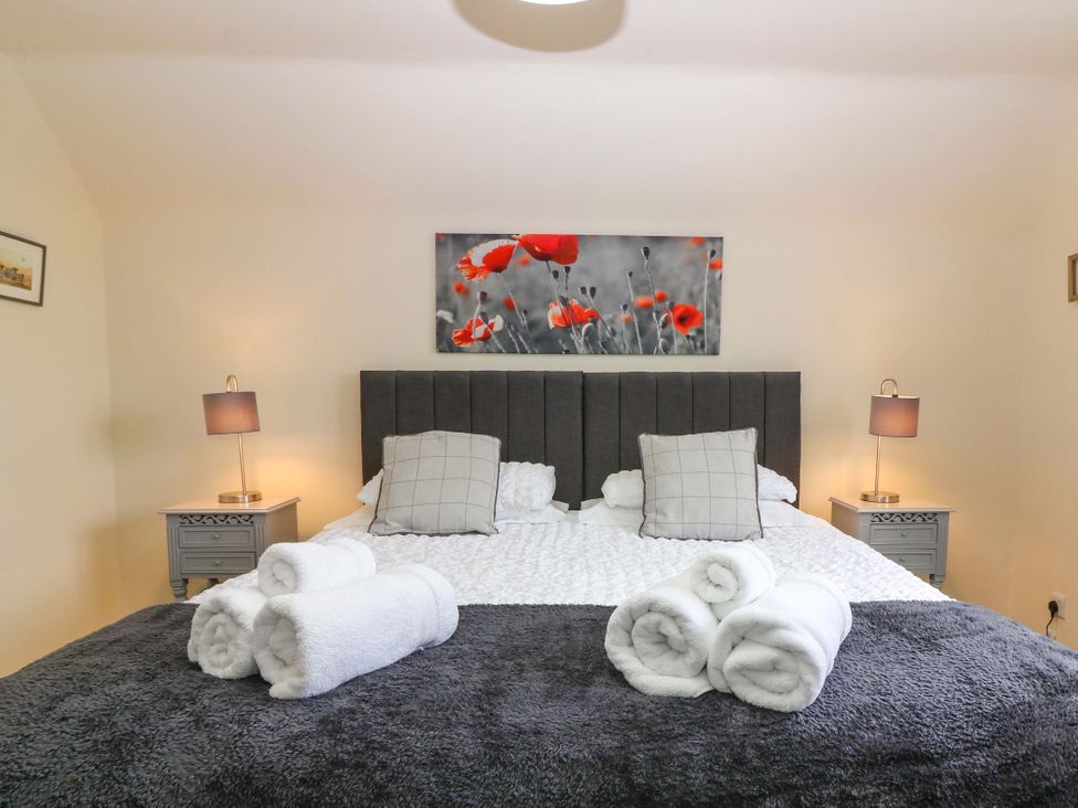 A bedroom with a bed and bedside tables at Falla Farmhouse in Jedburgh