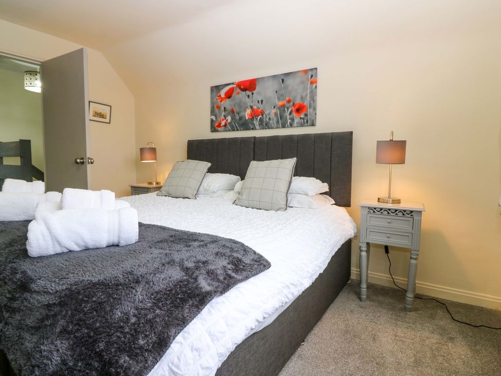 A bedroom with a bed and wall art at Falla Farmhouse in Jedburgh