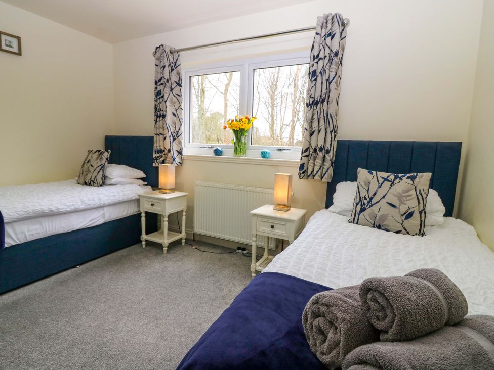A bedroom with two beds and a flower vase at Falla Farmhouse in Jedburgh