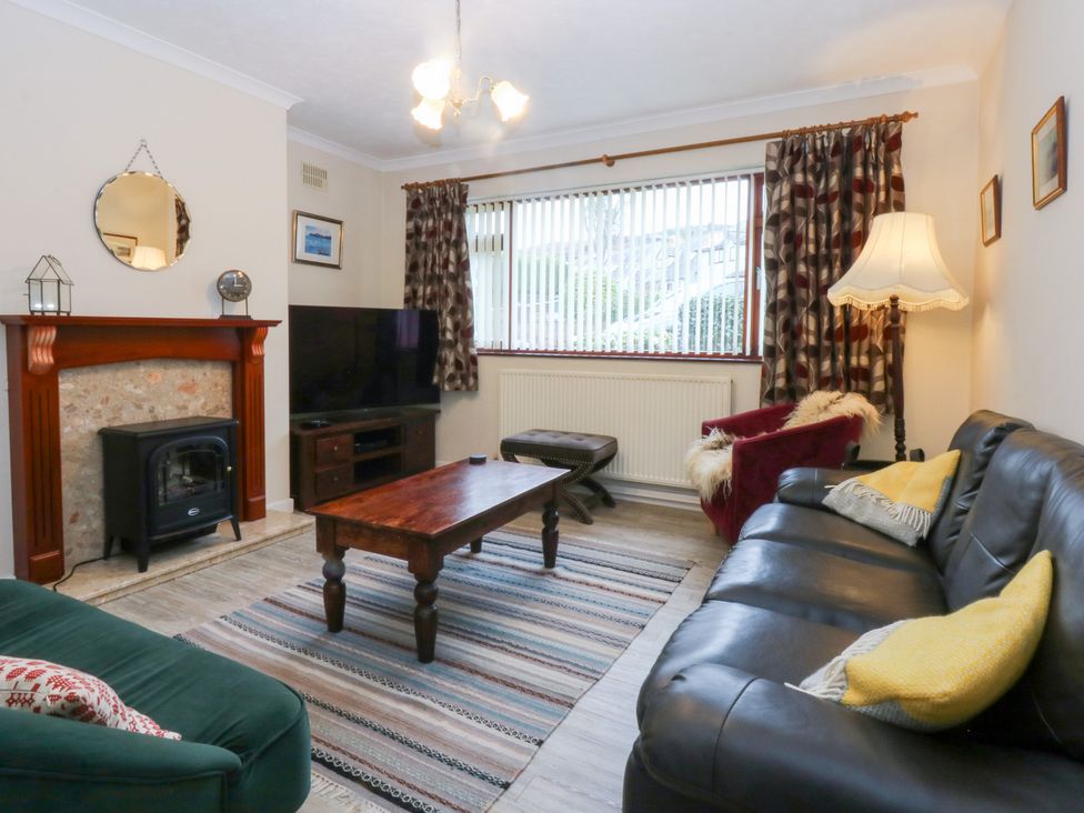 A living room with a television and fireplace at Eryl in Nefyn