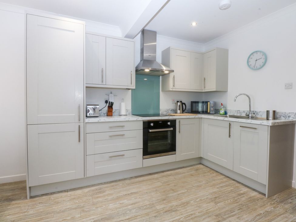 A kitchen with cabinets and appliances at Eryl in Nefyn