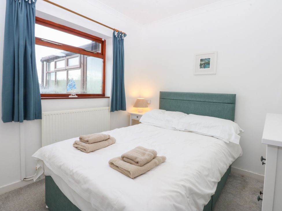 A bedroom with a bed and towels on it at Eryl in Nefyn