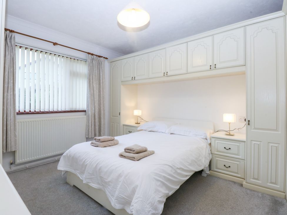 A bedroom with a bed and bedside tables at Eryl in Nefyn