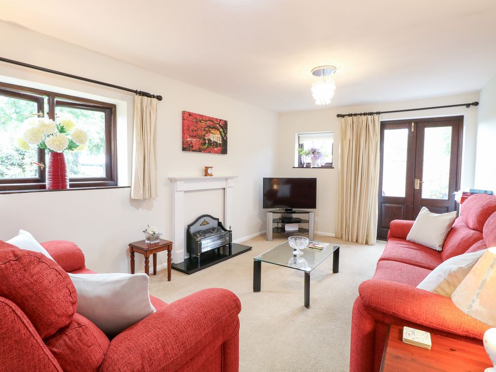 A living room with a television and a coffee table at Lowbrook Cottage in Dickleburgh near Diss