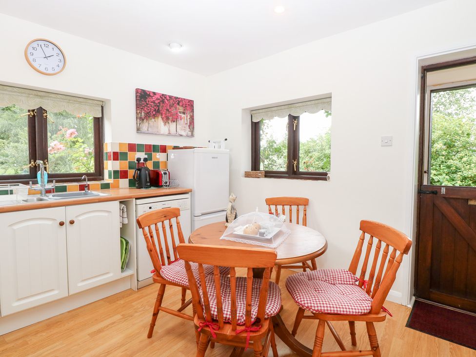 A kitchen with a dining table and chairs at Lowbrook Cottage in Dickleburgh near Diss