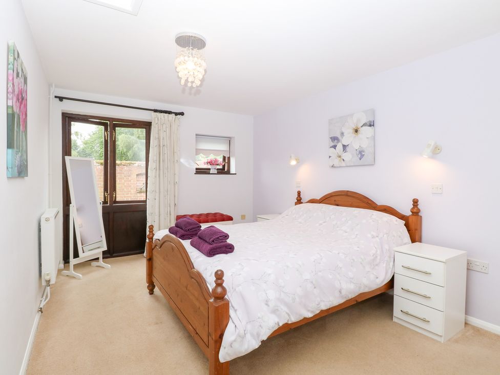 A bedroom with a double bed and a window at Lowbrook Cottage in Dickleburgh near Diss